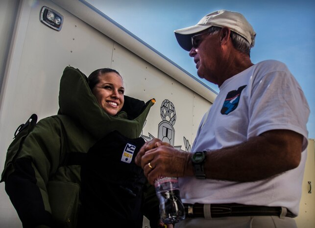 Airman 1st Class Amber Taft, 628th Civil Engineer Squadron Explosive Ordnance Disposal apprentice, speaks with Chester Galloway, a family member of a 437th Troop Carrier Group veteran, during an EOD display Sept. 28, 2012, at Joint Base Charleston – Air Base, S.C. The bomb suit is worn by trained personnel when disposing bombs. (U.S. Air Force Photo / Airman 1st Class Tom Brading)