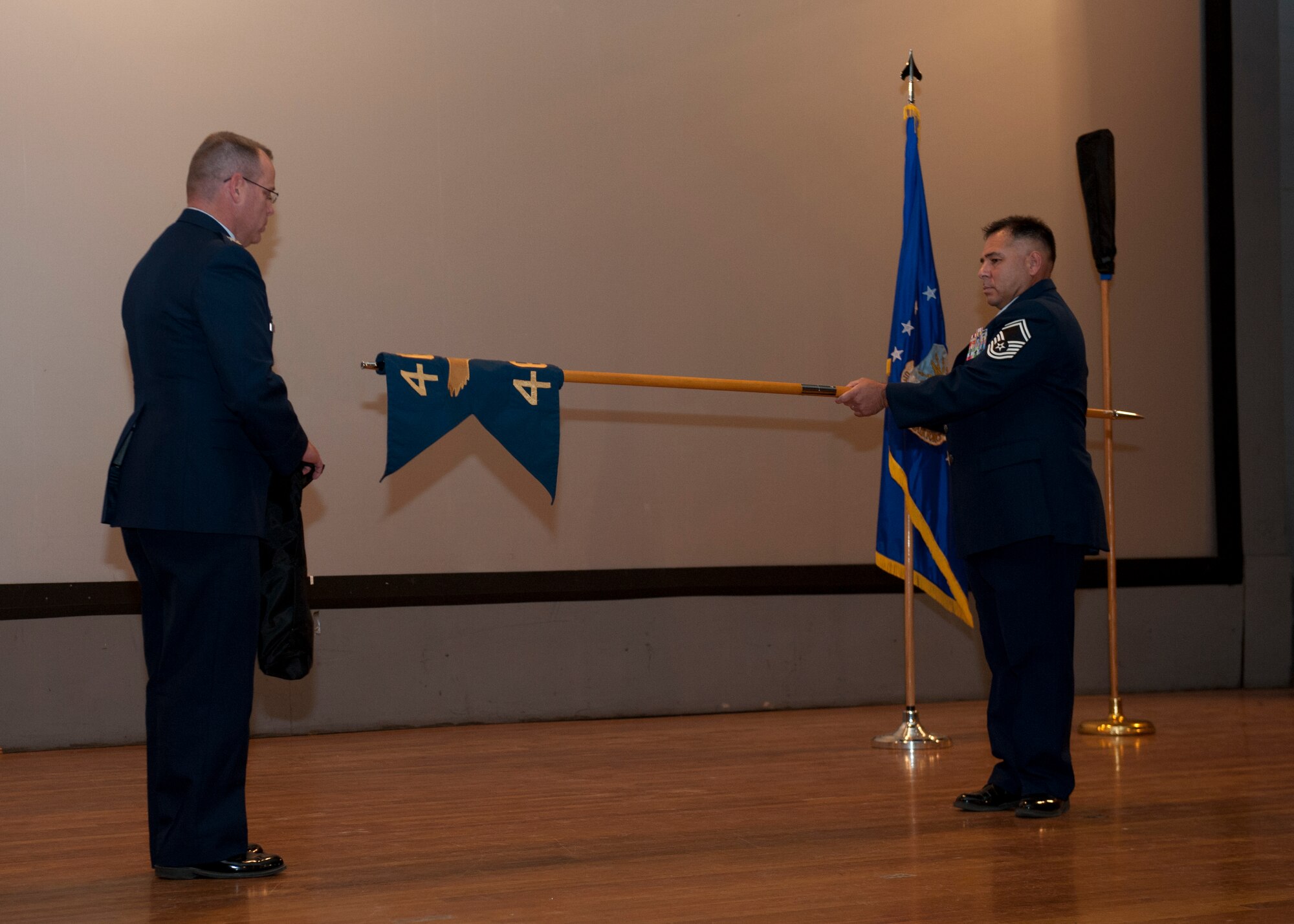 Colonel Charles Webb, 96th Test Group commander, and Senior Master Sgt. Raul Cabral, 96th Test Group superintendent, cover the 46th Test Group's guidon to symbolize its de-activation at Holloman Air Force Base, N.M., Oct. 1. The 96th Test Group was redesigneted to take the place of the 46th Test Group at Holloman AFB. The 96th Test Group will maintain the same mission and manning as the 46th Test Group, but under a different designation. (U.S. Air Force photo by Airman 1st Class Daniel E. Liddicoet/Released)