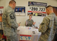 Airman 1st Class Brittany Shaw, voting officer for the 319th Operation Support Squadron, provides information on absentee ballot registration to fellow Airmen Oct. 1, 2012, at the Exchange on Grand Forks Air Force Base, N.D. Shaw and other voting officers can be found helping Airmen with their voting concerns at the 319th Air Base Wing Installation Voting Office located next to the rock-climbing wall inside the base fitness center. The voting office is open Mondays and Wednesdays from 8 to 10 a.m., and Tuesdays from 3 to 5 p.m. (U.S. Air Force photo/Senior Airman Luis Loza Gutierrez)