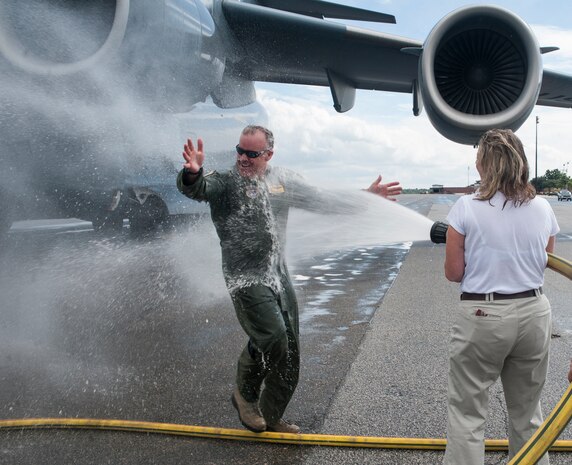 Col. Erik Hansen is hosed down with water by his wife Susan, after completion of his final flight as the 437th Airlift Wing commander at Joint Base Charleston - Air Base, S.C., Oct. 2, 2012. The final or "fini flight," is an aviation tradition in which aircrew members are met by their unit comrades, family and friends and soaked with water. (U.S. Air Force photo/ Airman 1st Class Ashlee Galloway) 