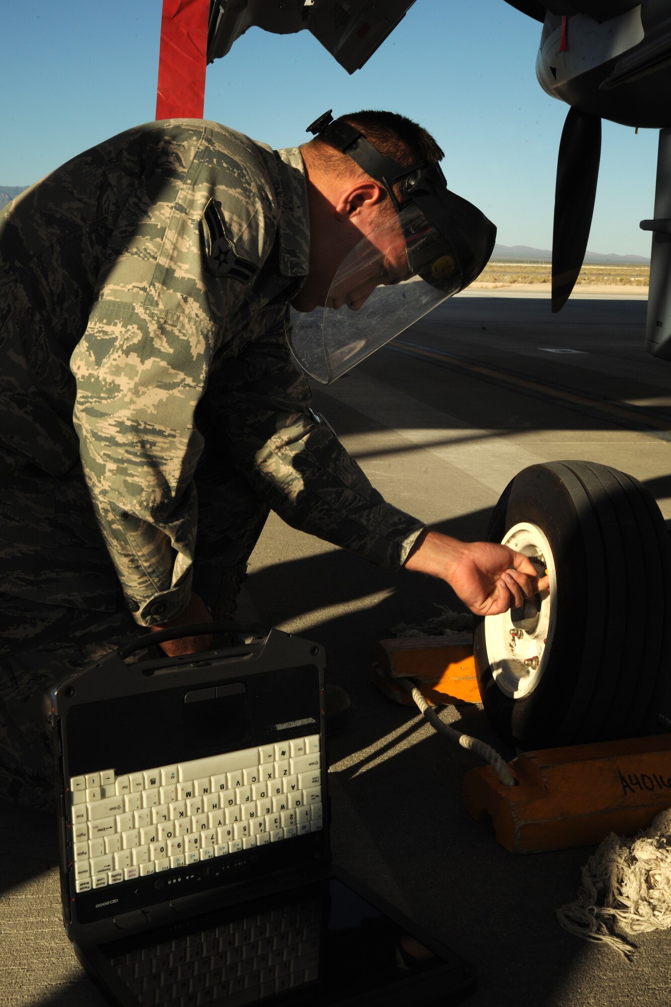 A crew chief assigned to the 432d Aircraft Maintenance Squadron checks the tire pressure of an MQ-9 Reaper remotely piloted aircraft (RPA) during a pre-flight inspection. An MQ-9’s primary missions are close air support, air interdiction, and intelligence, surveillance and reconnaissance. (U.S. Air Force photo by 432d Wing/432d Air Expeditionary Wing Public Affairs)
