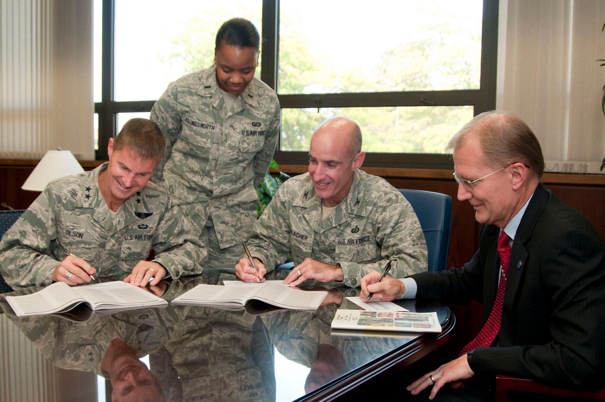 HANSCOM AIR FORCE BASE, Mass. – Maj. Gen. Craig S. Olson, C3I and Networks program executive officer; Col. Lester A. Weilacher, 66th Air Base Group commander; and Steve Wert, Battle Management program executive officer, complete their Combined Federal Campaign pledge cards as 1st Lt. Elicia Killingworth, Hanscom's CFC manager, looks on. The CFC main event will take place at the Minuteman Commons on Oct. 11 at 2:30 p.m. and features a race, chili cook-off, pie-in-the-face contest and themed basket auction. (U.S. Air Force photo Mark Wyatt)