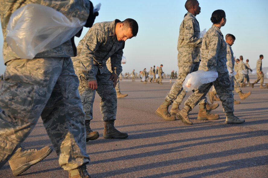 1st Lt. Anthony Hylko, 56th Civil Engineer Squadron programs flight deputy, picks up a piece of foreign object debris during the annual Wing FOD walk, Sept. 27. FOD is a substance, debris or article that can potentially cause damage to an F-16. (U.S. Air Force photo by Senior Airman Sandra Welch)