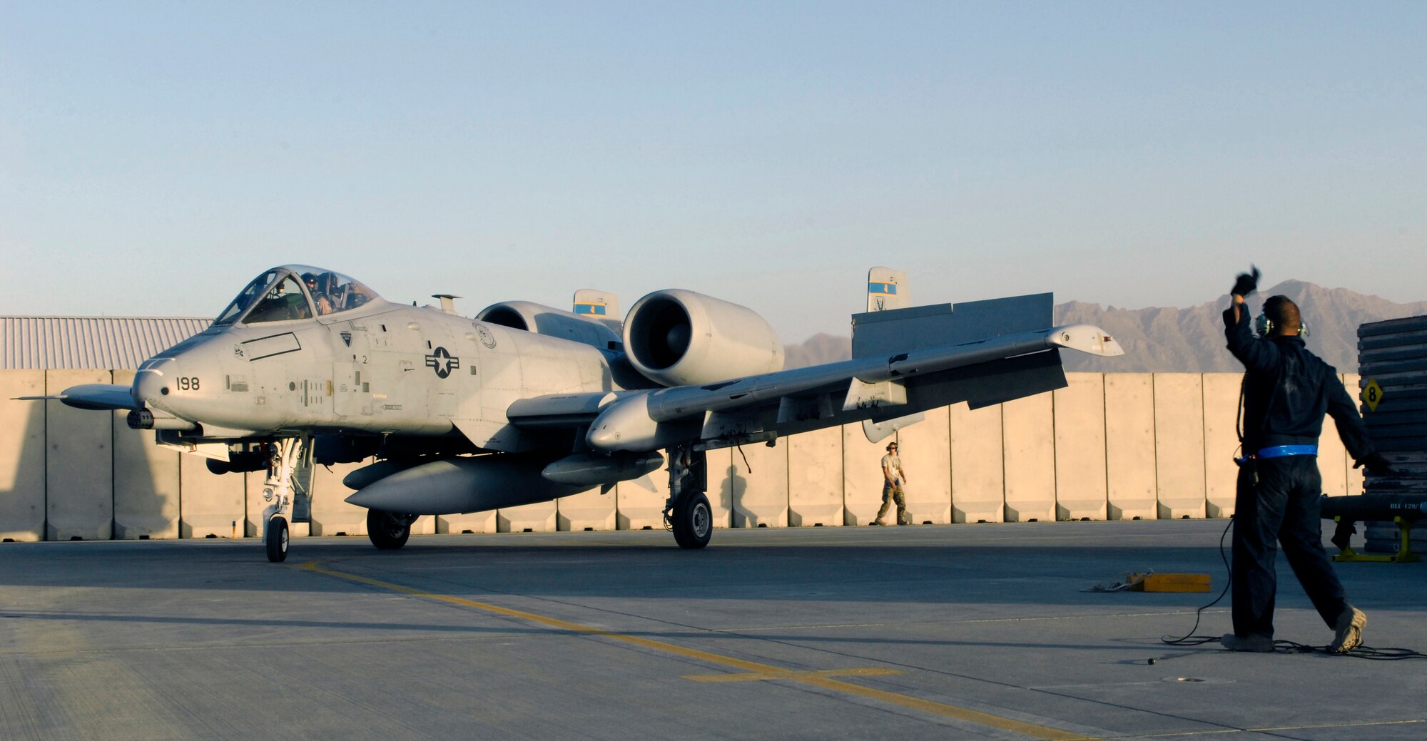 An aircraft maintainer from the 455th Expeditionary Aircraft Maintenance Squadron marshals a U.S. Air Force A-10 Thunderbolt II from Davis-Monthan Air Force Base’s 354th Fighter Squadron to its parking spot at Bagram Air Field, Afghanistan, Oct. 3, 2012. Davis-Monthan pilots and maintainers are some of the newest members of the 455th Air Expeditionary Wing. (U.S. Air Force Photo/Staff Sgt. Jeff Nevison)