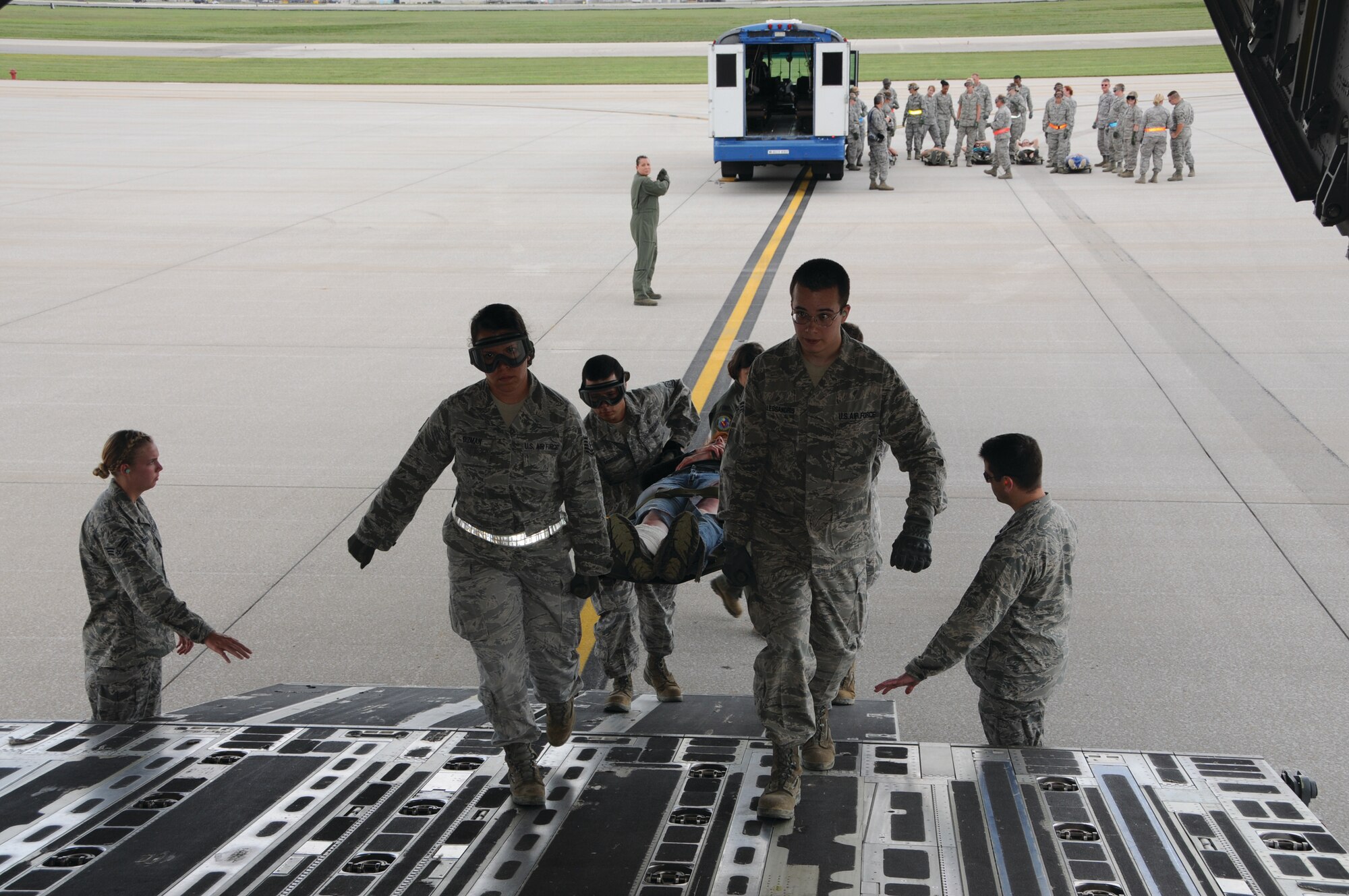 Tech. Sgt. Rebecca Guzman, 445th Aeromedical Staging Squadron aerospace medicine services craftsman, Senior Airman Robert Dallessandris, 445 AMDS medical services technician and other medical personnel, carry a “patient” on an awaiting C-17 during the disaster response exercise Sept.  9. (Capt. John Stamm)