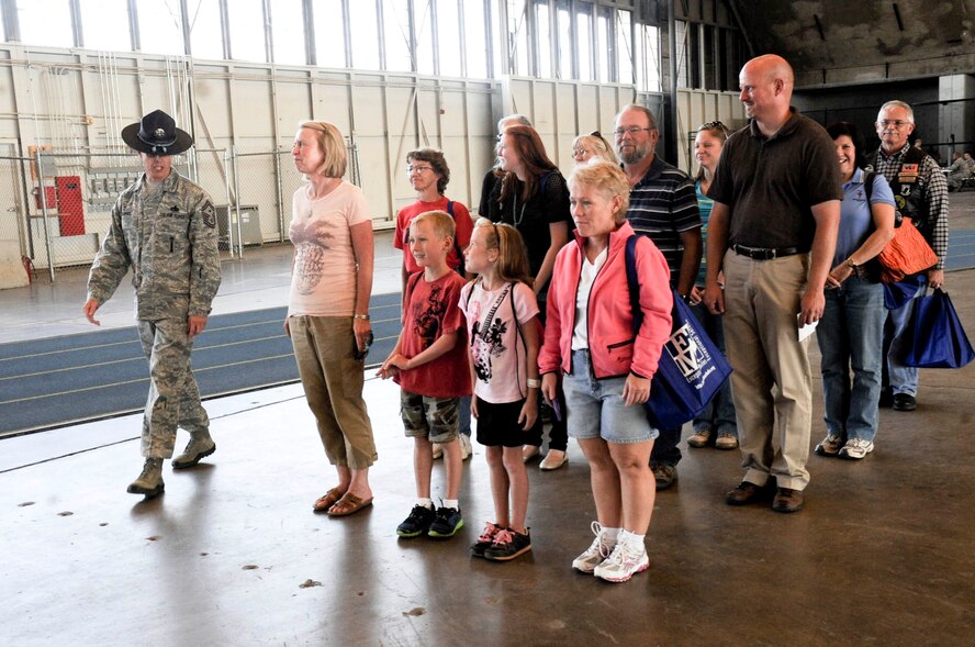 Senior Master Sgt. Richard Dupree, Logistics Readiness Squadron first sergeant, guides a formation of children and spouses of military members and teachers from the Douglas and Rapid City School districts during Kudos, Sudos and Tudos, an event designed to help understand deployment operations, at the Pride Hangar at Ellsworth Air Force Base, S.D., Sept. 29,2012. The Airman and Family Readiness Center, along with members of Team Ellsworth, offered family members and teachers an opportunity to interact with base agencies to learn about both the deployment process and military procedures. (U.S. Air Force photo by Airman 1st Class Anania Tekurio/released)