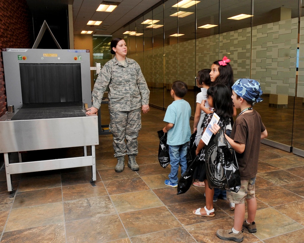 Second Lt. Kristen Miranda, 28th Force Support Squadron military personnel section chief, brief children on the deploying process  during the kids, spouses and teachers understanding deployment operations event at the deployment center at Ellsworth Air Force Base, S.D., Sept. 29, 2012. Children and spouses of military members, along with teachers from the Douglas and Rapid City school districts, were provided an opportunity to interact with different base agencies and better understand what family members experience during deployments. (U.S. Air Force photo by Airman 1st Class Anania Tekurio/Released)
