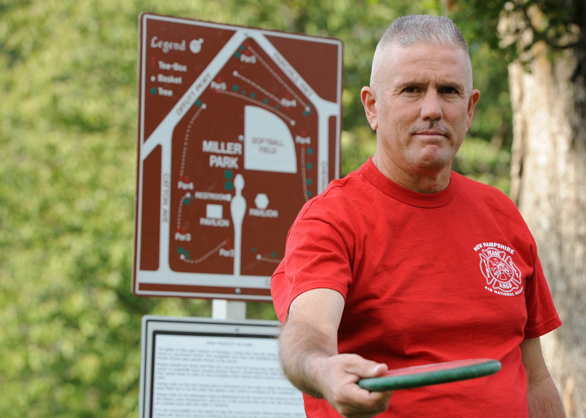 Tech. Sgt. Larry C. Kirk, 144th Maintenance Squadron aerospace ground equipment technician, poses for a photo by the nine-hole disc golf map at Miller Park on Fairchild Air Force Base, Wash., Oct. 1, 2012. Kirk is completing his second 50-state tour of the U.S. (U.S. Air Force photo by Staff Sgt. Michael Means)