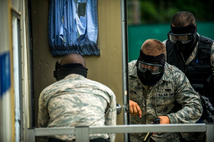 (Left to right) Airman Basic Jeremy Erving, Airman 1st Class Robert Loftin and Staff Sgt. Ellis Bowles, 628th Security Forces Squadron, stack up  to clear a room during an active shooter scenario Sept. 26, 2012, at Joint Base Charleston - Weapons Station, S.C. During the scenario, Airmen practiced entering a house under control of hostile forces and eliminated the threat while identifying and controlling non-hostile inhabitants. Security Forces Airmen test their skills and knowledge in simulated hostile environments to prepare for real-world events. (U.S. Air Force photo/Airman 1st Class George Goslin)