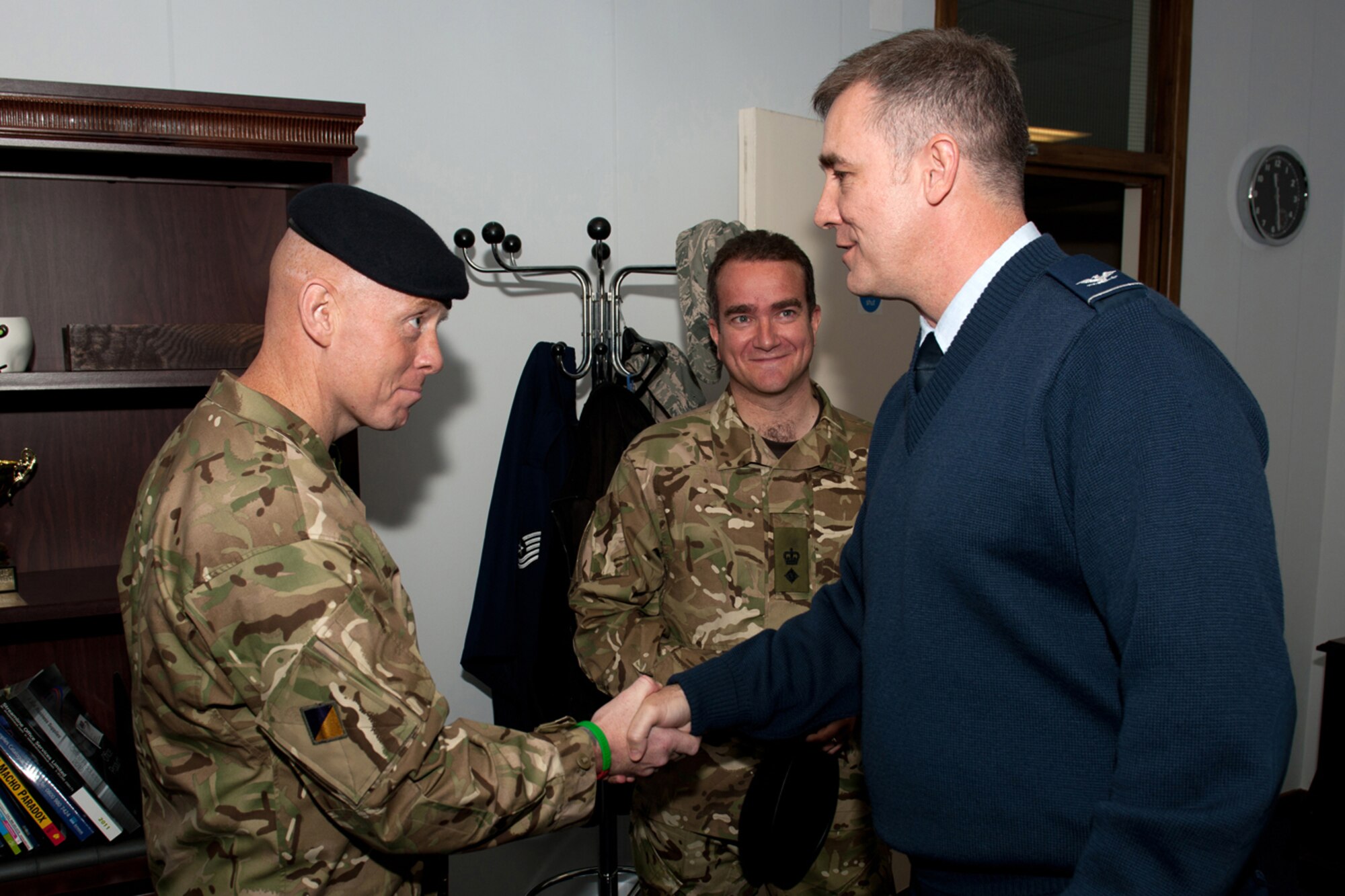 RAF CROUGHTON, United Kingdom – Col. Charles Hamilton, 422nd Air Base Group commander, coins Royal Marine Regimental Sergeant Major W. Fuller, 23rd Pioneer Regiment, after presenting Royal Marine Lt. Col. D. Clouston, 23rd Pioneer Regiment commanding officer, with a check for £200. Team Croughton raised the money for two members of the regiment killed in Afghanistan in May. The 23rd Pioneer Regiment is based near RAF Croughton in Bicester, Oxfordshire. (U.S. Air Force photo by Master Sgt. John Barton)