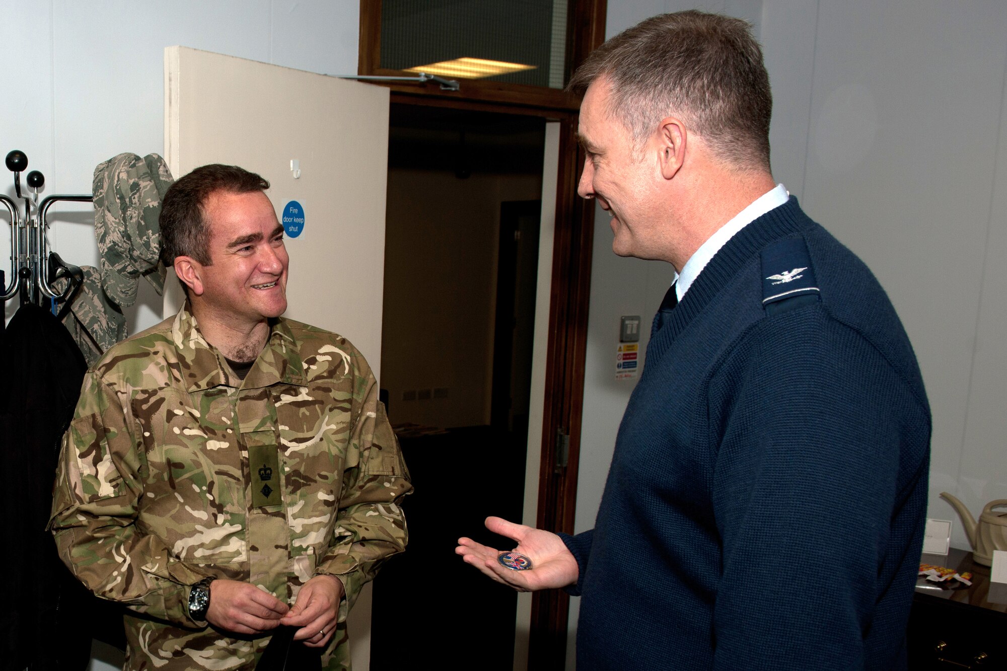 RAF CROUGHTON, United Kingdom – Col. Charles Hamilton, 422nd Air Base Group commander, coins Royal Marine Lt. Col. D. Clouston, 23rd Pioneer Regiment commanding officer, after presenting him with a check for £200. Team Croughton raised the money for two members of the regiment killed in Afghanistan in May. The 23rd Pioneer Regiment is based near RAF Croughton in Bicester, Oxfordshire. (U.S. Air Force photo by Master Sgt. John Barton)