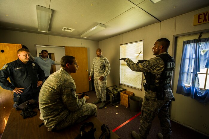 Participants in an active shooter scenario debrief after a raid Sept. 26, 2012, at Joint Base Charleston - Weapons Station, S.C. During the scenario, Airmen practiced combative moves before entering a house under control of hostile forces and eliminated the threat while identifying and controlling non-hostile inhabitants. Security Forces Airmen test their skills and knowledge in simulated hostile environments to prepare for real-world events. (U.S. Air Force photo/Airman 1st Class George Goslin)