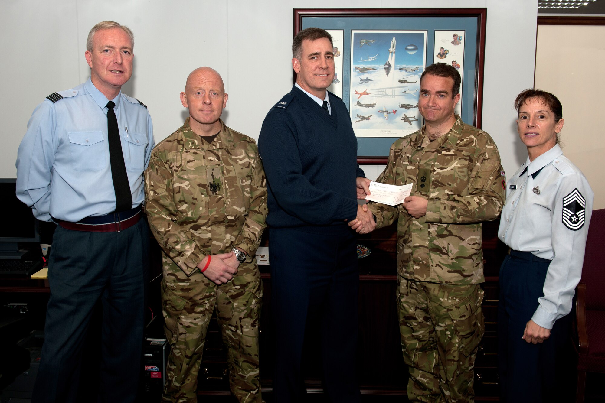 RAF CROUGHTON, United Kingdom – Col. Charles Hamilton, 422nd Air Base Group commander, presents Royal Marine Lt. Col. D. Clouston, 23rd Pioneer Regiment commanding officer, with a check for £200. Team Croughton raised the money for two members of the regiment killed in Afghanistan in May. The 23rd Pioneer Regiment is based near RAF Croughton in Bicester, Oxfordshire. (U.S. Air Force photo by Master Sgt. John Barton)