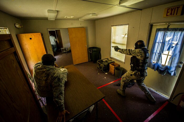 Staff Sgt. Ellis Bowles, 628th Security Forces Squadron, simulates firing his M9 pistol during an active shooter scenario Sept. 26, 2012, at Joint Base Charleston - Weapons Station, S.C. During the scenario, Airmen practiced entering a house under control of hostile forces and eliminated the threat while identifying and controlling non-hostile inhabitants. Security Forces Airmen test their skills and knowledge in simulated hostile environments to prepare for real-world events. (U.S. Air Force photo/Airman 1st Class George Goslin)