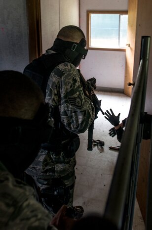 Airman Basic Jeremy Erving, 628th Security Forces Squadron, simulates firing his M4 carbine pistol during an active shooter scenario Sept. 26, 2012, at Joint Base Charleston - Weapons Station. During the scenario, Airmen practiced entering a house under control of hostile forces and eliminated the threat while identifying and controlling non-hostile inhabitants. Security Forces Airmen test their skills and knowledge in simulated hostile environments to prepare for real-world events. (U.S. Air Force photo/Staff Sgt. Rasheen Douglas)