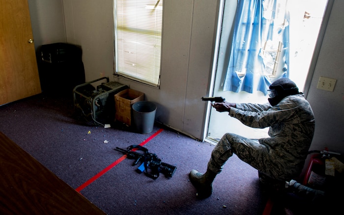 Airman Basic Jeremy Erving, 628th Security Forces Squadron, simulates firing his M9 pistol during an active shooter scenario Sept. 26, 2012, at Joint Base Charleston - Weapons Station, S.C. During the scenario, Airmen practiced entering a house under control of hostile forces and eliminated the threat while identifying and controlling non-hostile inhabitants. Security Forces Airmen test their skills and knowledge in simulated hostile environments to prepare for real-world events. (U.S. Air Force photo/Staff Sgt. Rasheen Douglas)