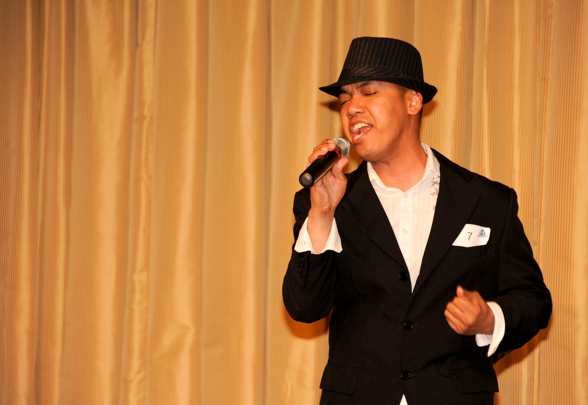 Staff Sgt. Oliver Dagum, 305th Aerial Port Squadron training instructor, originally from Tulsa, Okla., sings "Ain't no sunshine," by Alicia Keys, during the Air Mobility Command Icon singing competition held at Tommy B's Community Activities Center here Aug. 16. Dagum finished third, taking home $200, but is going on to the next round because the second place finisher, Senior Airman Benjamin Florez, 305th Aerial Port Squadron  ramp specialist or "port dawg," is set to deploy.(U.S. Air Force photo by 2nd Lt. David J. Murphy/Released)