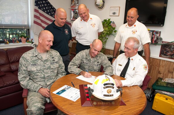 HANSCOM AIR FORCE BASE, Mass. – Col. Lester A. Weilacher, 66th Air Base Group commander, signs a proclamation declaring Oct. 7 to 13 as Fire Prevention Week on Hanscom, as Chief Bob Hildreth (front right), Chief Master Sgt. Baird Stiefel (front left), 66th Air Base Group superintendant, and other members of the Hanscom Fire Department gather around. This year's Fire Prevention Week theme, "Have Two Ways Out," focuses on the importance of a fire escape plan and practicing it. (U.S. Air Force photo by Rick Berry)