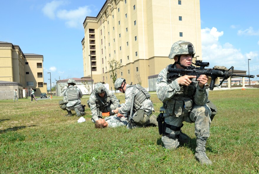 Airman 1st Class Daniel Sperling, far right, 8th Security Forces Squadron Assassins flight, keeps watch over Alpha flight as they administer self-aid and buddy care during the Defenders Challenge Sept. 28, 2012, at Kunsan Air Base, Republic of Korea. From basic military training to deployments, SABC is a skill they will be tested on repeatedly. (U.S. Air Force photo/Senior Airman Brigitte N. Brantley)
