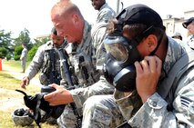 Airman 1st Class Nickolas Trowbridge, center, 8th Security Force Squadron Alpha flight, takes a deep breath after taking off his gas mask during the Defenders Challenge Sept. 28, 2012, at Kunsan Air Base, Republic of Korea. As part of the challenge, competitors donned their gas masks and sprint around a field before assembling an M16 rifle and function-checking an M9 handgun. (U.S. Air Force photo/Senior Airman Brigitte N. Brantley)