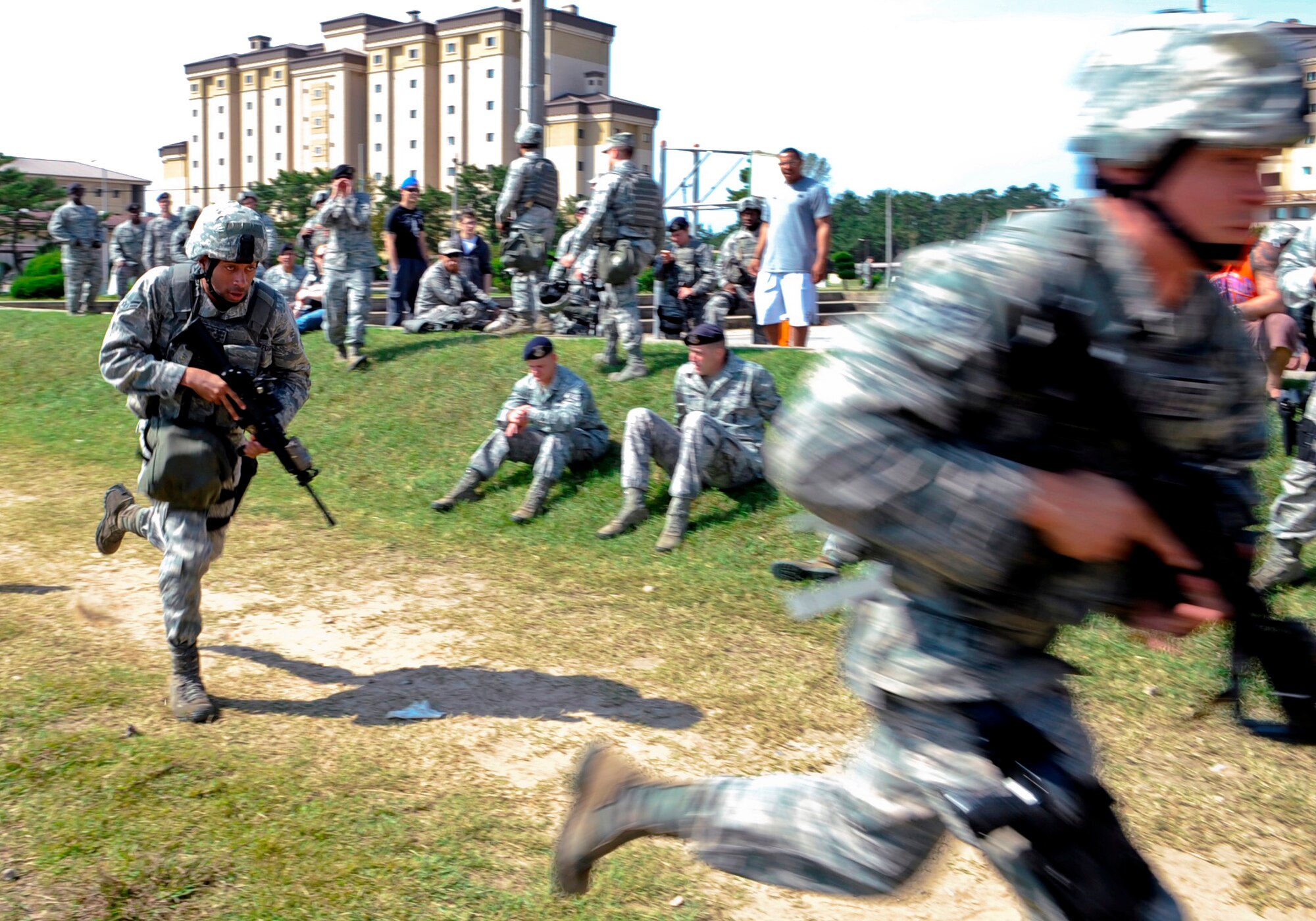 Airman 1st Class Anthony Sanders, left, 8th Security Force Squadron Assassins flight, sprints from one station to the next as teammates cheer him on during the Defenders Challenge Sept. 28, 2012, at Kunsan Air Base, Republic of Korea. During the challenge, flights went head-to-head as they proved their proficiency in skills learned throughout the month. (U.S. Air Force photo/Senior Airman Brigitte N. Brantley)