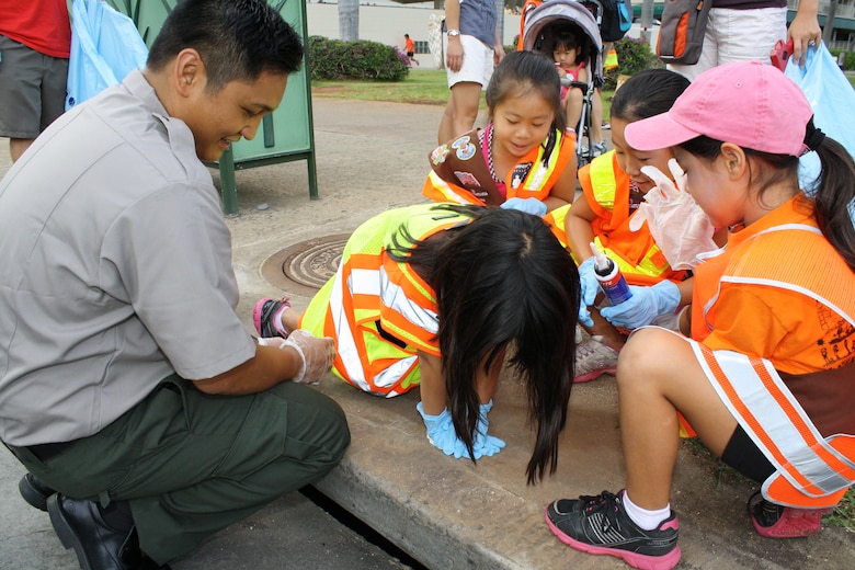 Park Ranger Don Espaniola of the Corps’ Regional Visitor Center, helps Girl Scout Brownie Troop 276 install a storm drain marker as part of National Public Lands Day Sept. 29.   The drain markers remind people to dump no waste since the water drains to the ocean. More than 60 volunteers scoured Fort DeRussy in Waikiki, picking up trash and installing storm drain markers as part of the national event. The Corps’ Regional Visitor Center coordinated the event which was supported by Corps employees, Iolani School’s Brownie Troop 276 and Punahou Junior ROTC cadets.