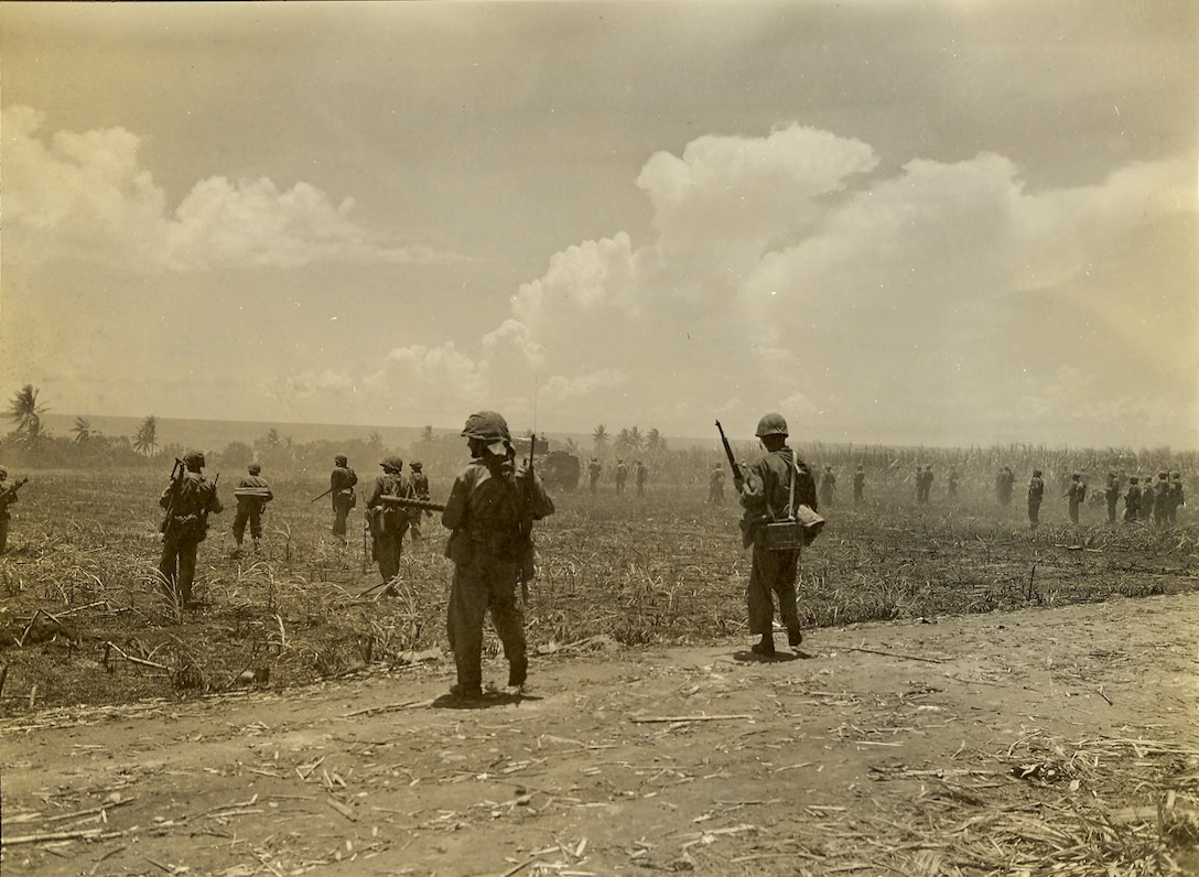 "Showing the front line boys moving behind tanks on Saipan."