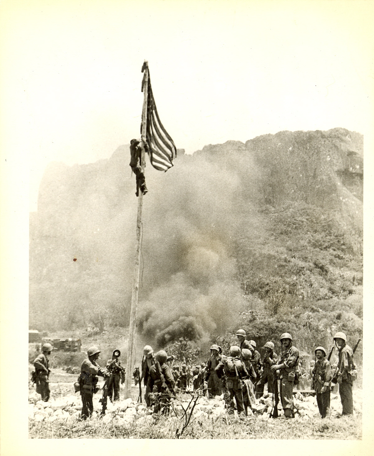 "Flag raising on northern end of Saipan. The boys did this just before reaching the water's edge. I saw this from atop the hill in the background. Don't look (too) closely because I doubt if you can find me."