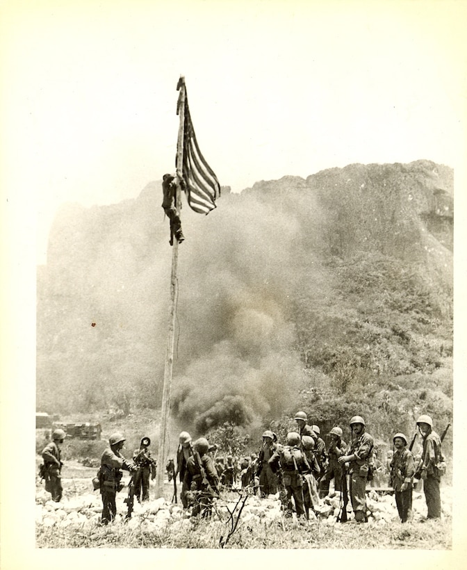 "Flag raising on northern end of Saipan. The boys did this just before reaching the water's edge. I saw this from atop the hill in the background. Don't look (too) closely because I doubt if you can find me."