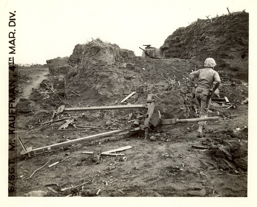 In front is an overturned Japanese anti tank gun, in back is a knocked out Japanese light tank in a fortified position.