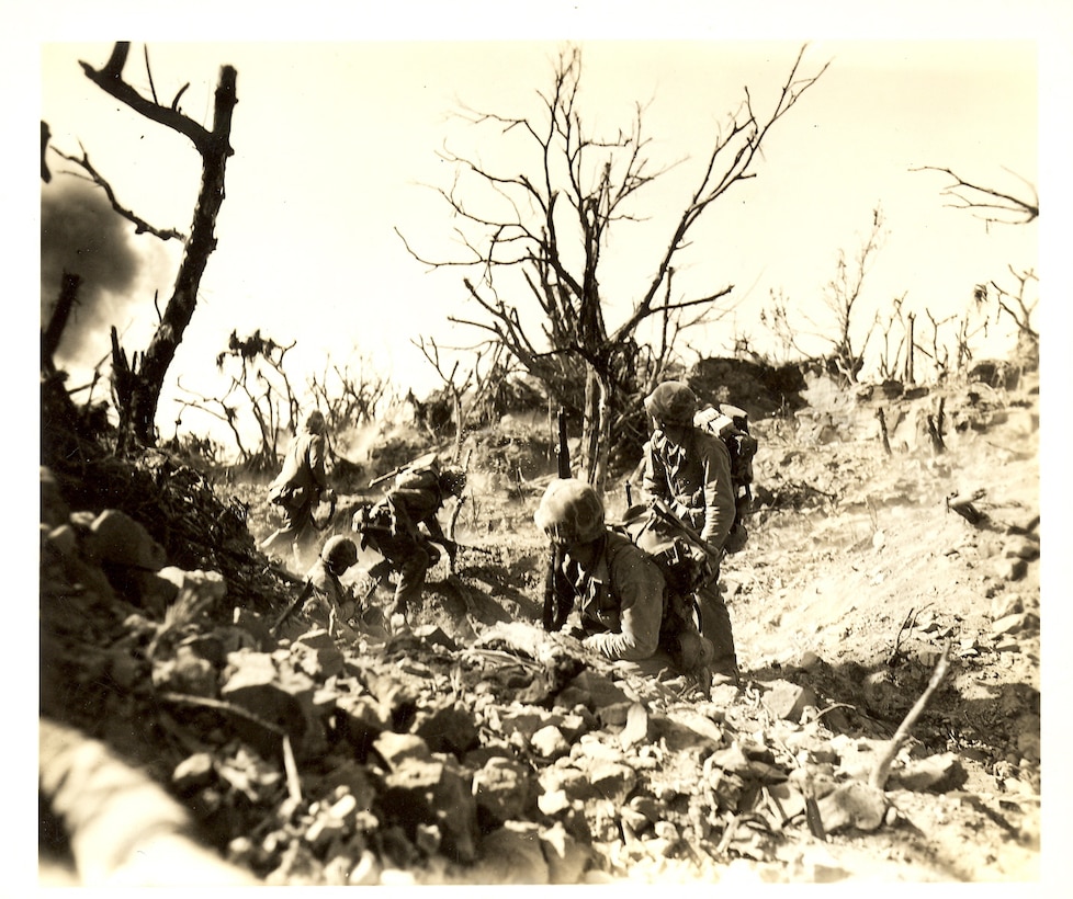 Marines observing an explosion in the distance.