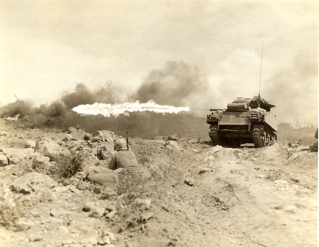 Marines wait for a flame thrower tank to attack and eliminate a Japanese position.