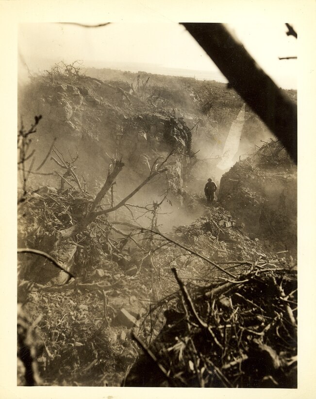 A Marine searches rock crevice for Japanese positions.