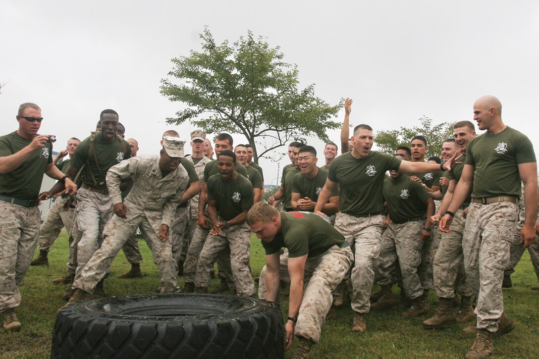 Marines cheer and support their team for the tire-flip challenge during warrior day at Combined Arms Training Center Camp Fuji Sept. 20. Marines marked the end of Artillery Relocation Training Program 12-2 by competing in multiple events, including the obstacle course, confidence course and a weapons assembly scramble during the warrior day. 