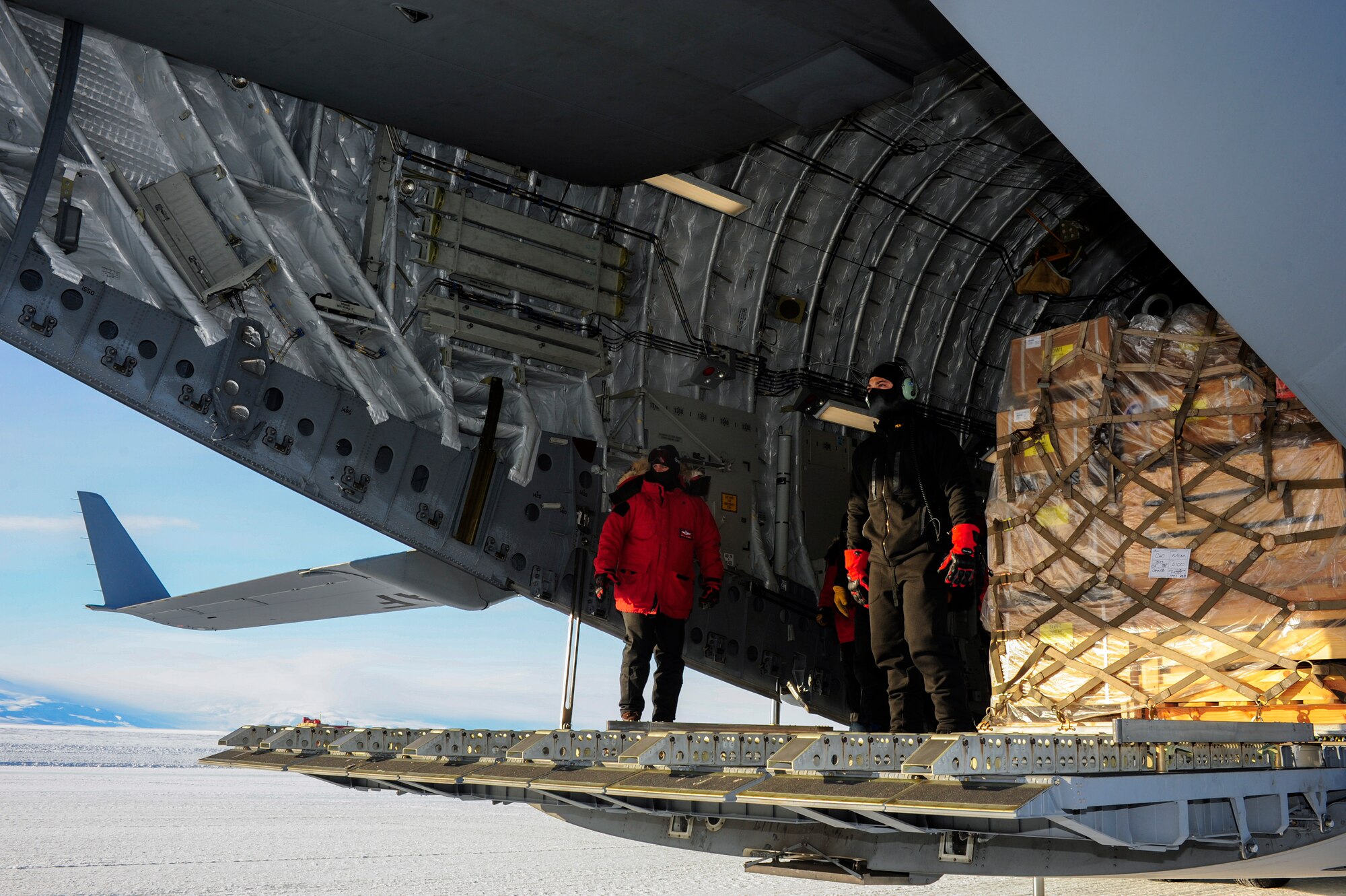 Loadmasters from the 62nd and 446th Airlift Wings, Joint Base Lewis-McChord, Wash., wearing extreme cold weather gear, await a forklift, Oct. 1, 2012, at McMurdo Station, Antarctica. The weather at the research center reached minus 35 degrees Fahrenheit. (U.S. Air Force photo/Staff Sgt. Sean Tobin)