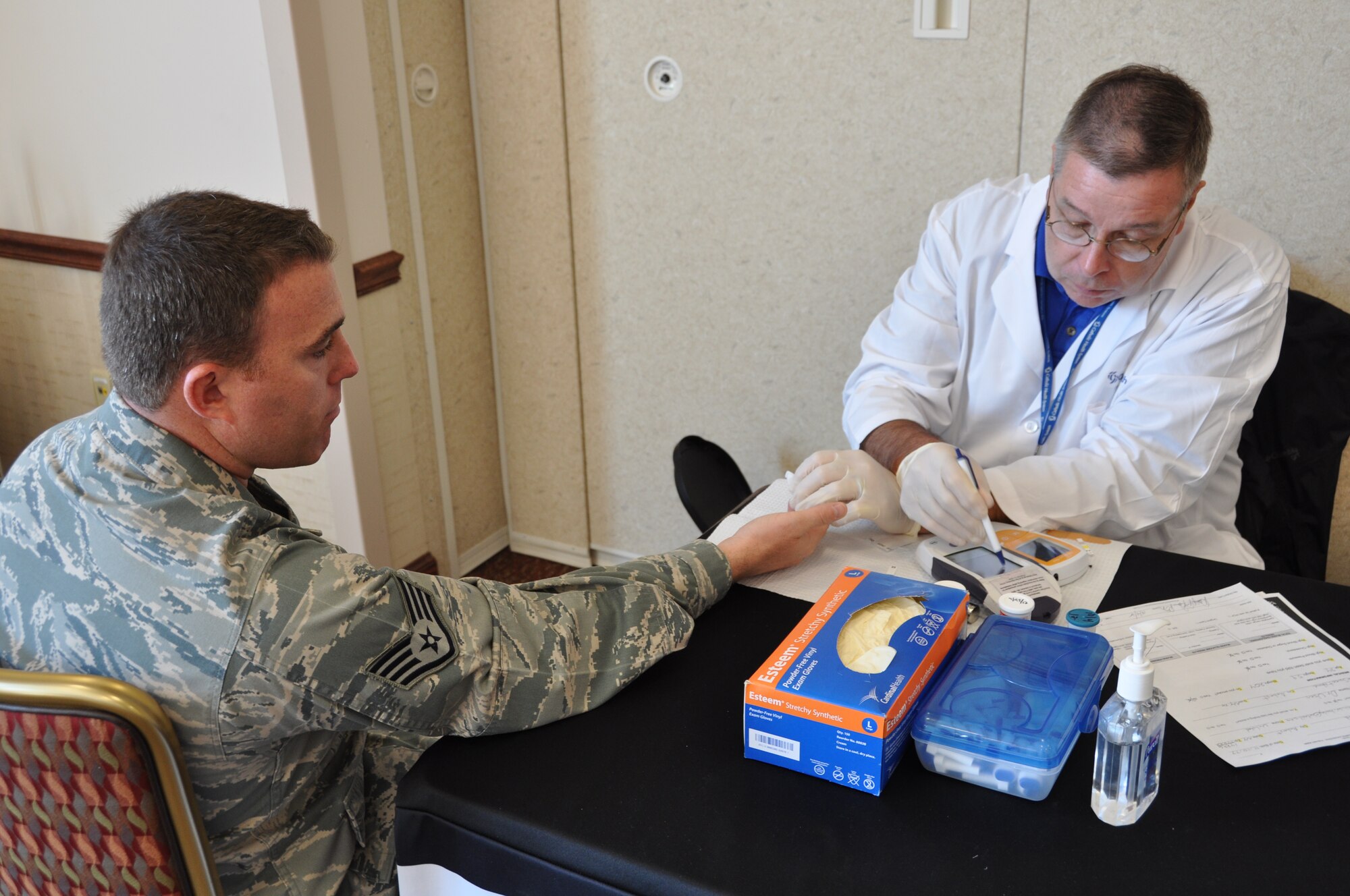 NIAGARA FALLS AIR RESERVE STATION, N.Y. - Staff Sgt. Martin Hanley, 107th Comptroller Flight, gets his blood sugar checked by Dave Roma, Catholic Health Community Nurse Educator, as part of a free health screening during a Wellness Seminar here October 4.  Over twenty vendors participated in this one day seminar hosted by the base that offered chair massages, bone density screening, nutrition info, smoking cessation, financial wellness, animal therapy and more.  (U.S. Air Force photo by Master Sgt. Kevin Nichols)