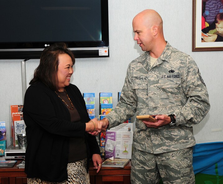 Elizabeth Kim, 9th Force Support Squadron work life consultant, receives the Diamond Recognition Award from Master Sgt. Jason Davis, 489th Reconnaissance Squadron first sergeant, at the Airman & Family Readiness Center, Beale Air Force Base Calif., Oct. 3, 2012. The Diamond Recognition Award is given to those who go above and beyond for Airmen and their families. (U.S. Air Force photo by Senior Airman Allen Pollard)