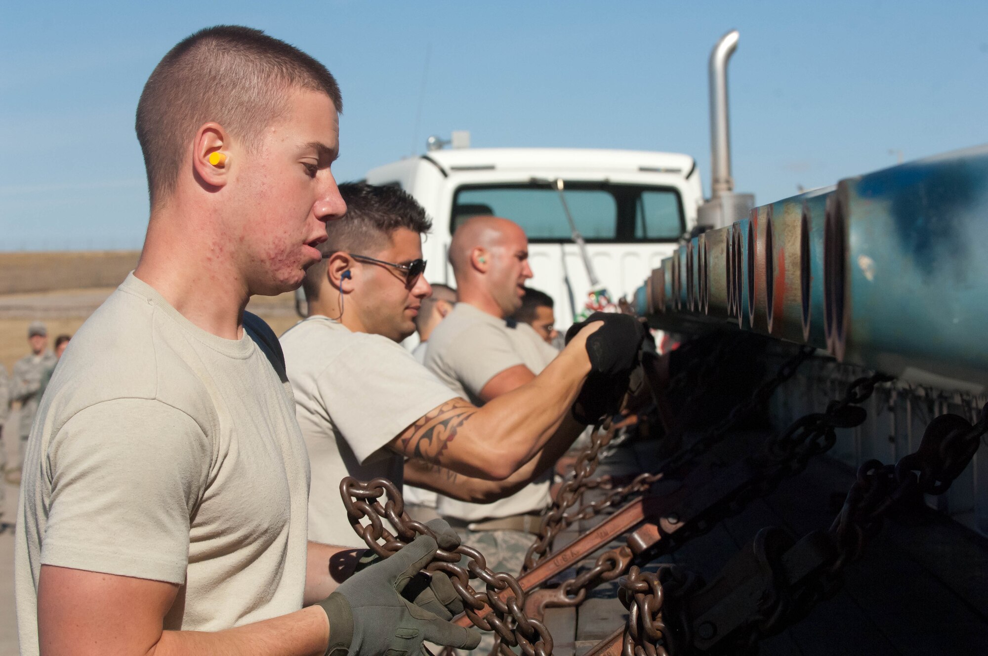 Members of the 28th Munitions Squadron, fasten and secure guided bomb units to a load trailer during the Global Strike Challenge at Ellsworth Air Force Base, S.D., Oct. 1, 2012. 450 competitors around the Air Force compete in Global strike challenge for the Fairchild trophy, which honors the best bomb wing in the Air Force. Ellsworth Airmen won the Global Strike Challenge in 2011 and prepared for months to return the Fairchild trophy to Ellsworth Air Force Base. (U.S. Air Force photo by Airman 1st Class Zachary Hada/Released)