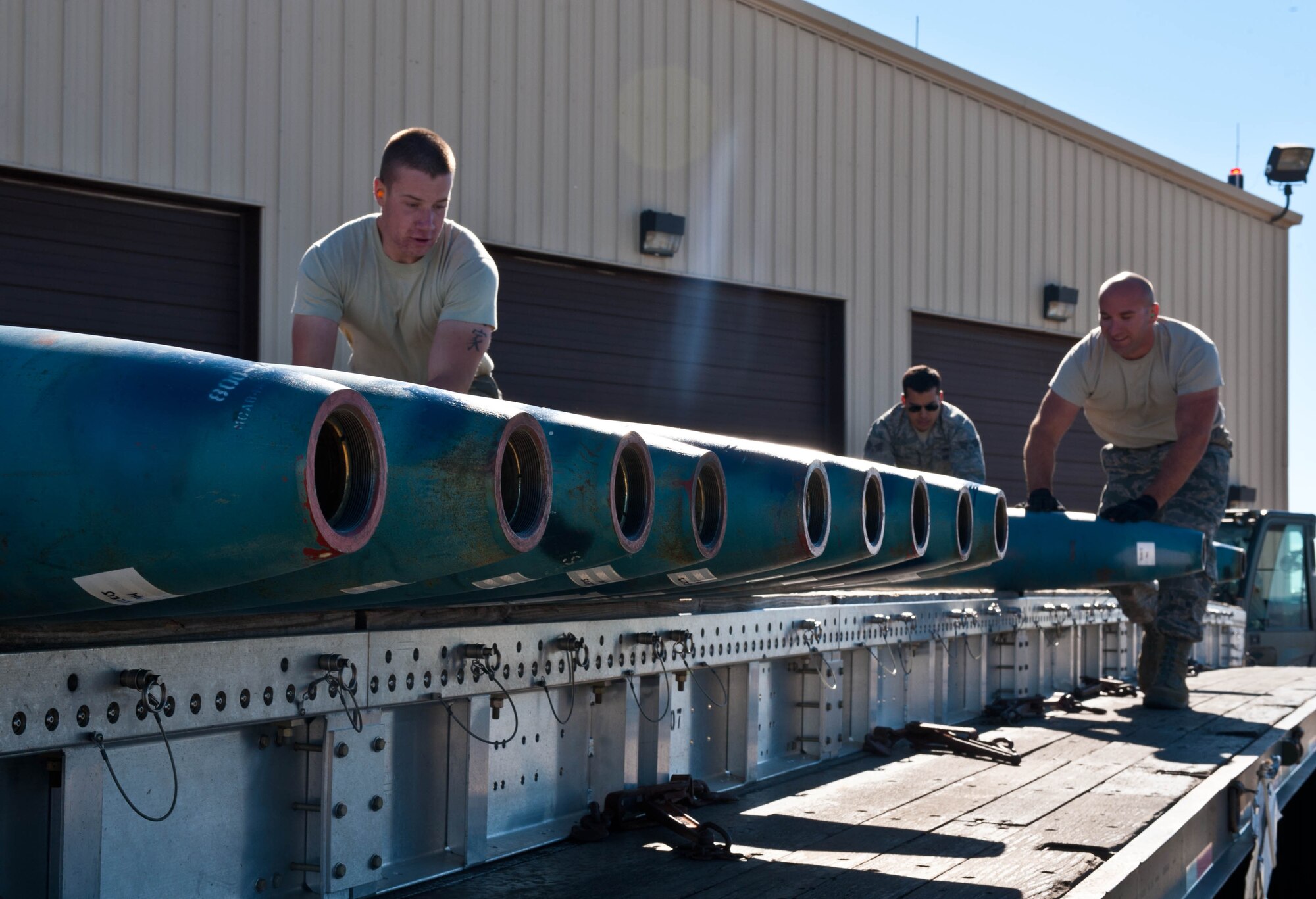 Airman 1st Class Christian Peterson, Staff Sgt. Anthony Anderson, and Staff Sgt. Joshua Gott, 28th Munitions Squadron line crewmembers, load guided bomb units onto a munitions trailer during the Global Strike Challenge at Ellsworth Air Force Base, S.D., Oct. 1, 2012. The 28th Bomb Wing is one of seven bomb wings participating in the Global Strike Challenge and compete for the title of the Air Force’s best bomber wing. (U.S. Air Force photo by Airman 1st Class Zachary Hada/Released)