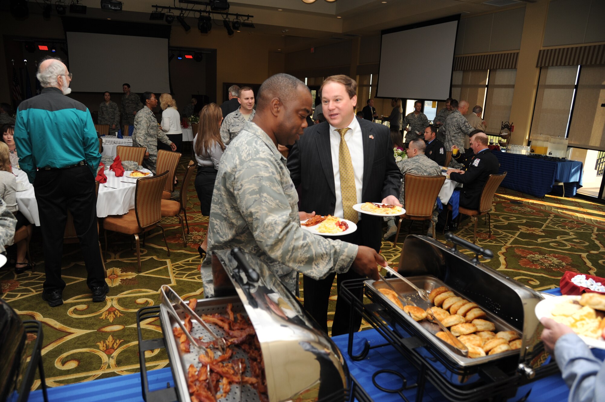 Col. Mark Vivians, 81st Mission Support Group commander, socializes with Michael Janus, D’Iberville city manager, while going through the breakfast buffet line at the Bay Breeze Event Center during the Biloxi Chamber of Commerce Morning Call Sept. 4, 2012, hosted by Keesler Air Force Base, Miss. (U.S. Air Force photo by Kemberly Groue)