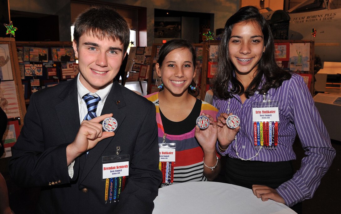 Brendon Kennedy, Abbey and Erin Butikofer, Robins Team Council members, display coins presented to them by retired Brig. Gen. Norman E. Arflack during the conference. (U. S. Air Force photo/Tommie Horton)