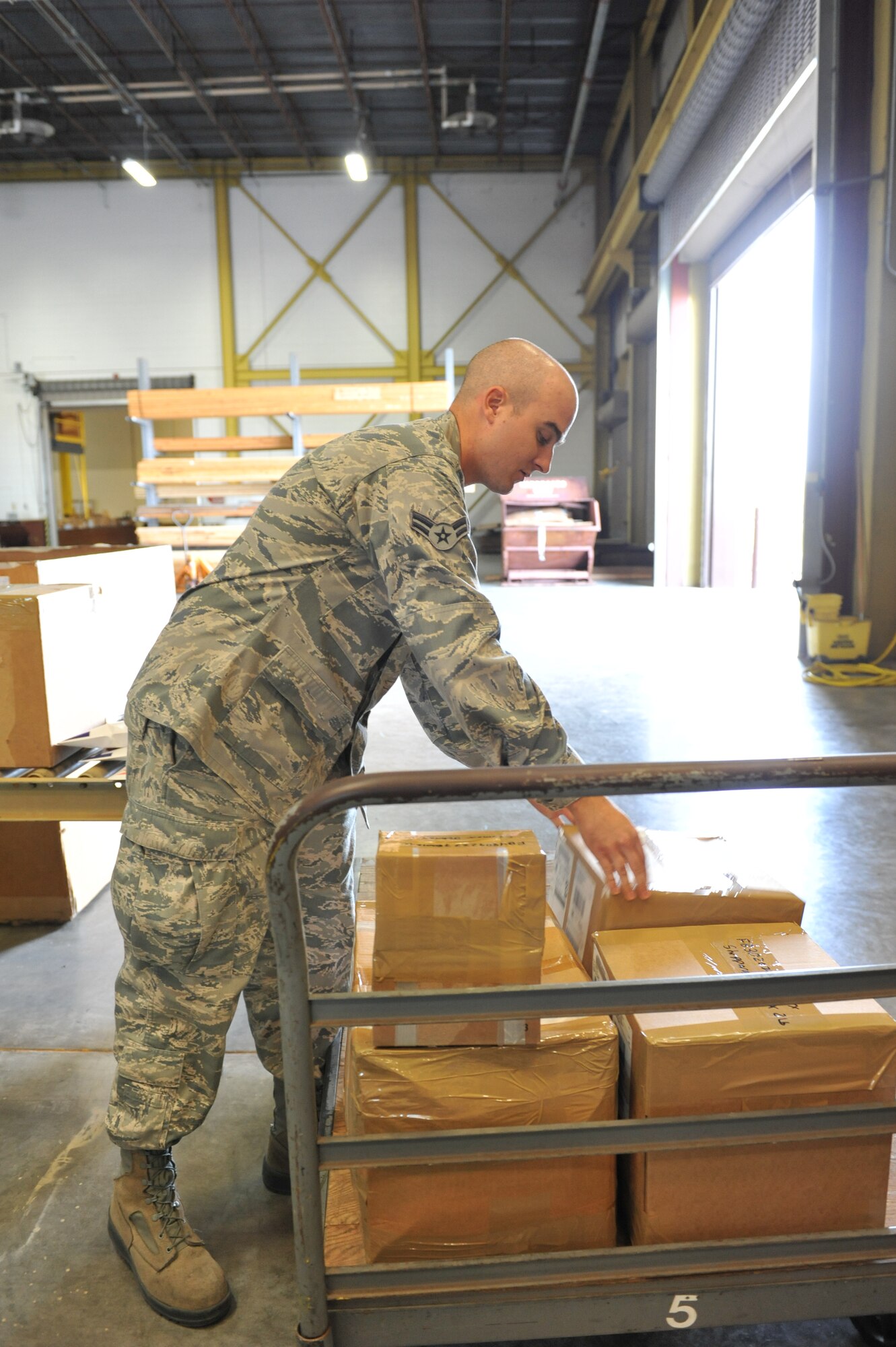 WHITEMAN AIR FORCE BASE, Mo. -- Airman 1st Class Michael Evseff, 509th Logistics Readiness Squadron packing and crating clerk, places packages to be sent off base Oct 1. (U.S. Air Force photo/Heidi Hunt) (Released)
