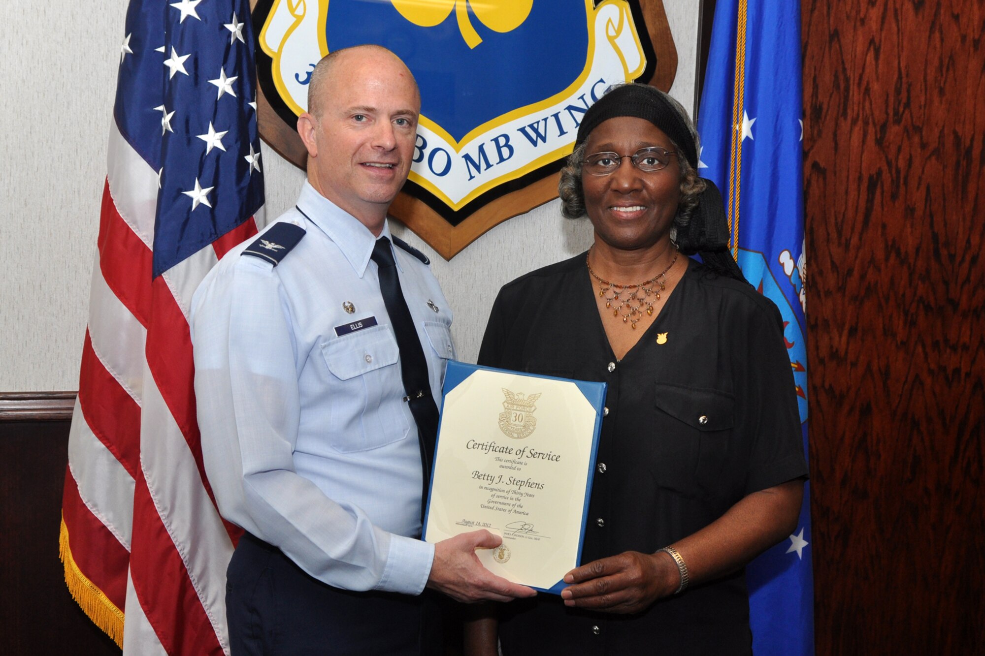 Col. Jonathan Ellis, the 307th Bomb Wing commander, and Betty Stephens, public affairs assistant, 307 BW, pose for a photo at Barksdale Air Force Base, La., Oct. 4, 2012. Stephens received a recognition certificate for 30 years of service in the Government of the United States of America. She started her career in 1982 at Fort Polk, La., and has also worked in Germany during her career. (U.S. Air Force photo by Master Sgt. Jeff Walston)