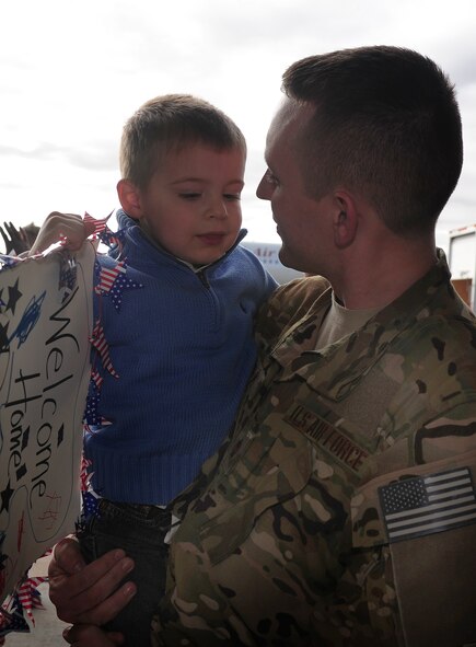 A service member greets his son during Operation Homecoming at Cannon Air Force Base, N.M., Oct. 4, 2012. Operation Homecoming is a monthly event held to welcome Air Commandos back from worldwide deployments and reunite them with family and friends. (U.S. Air Force photo/Airman 1st Class Ericka Engblom)