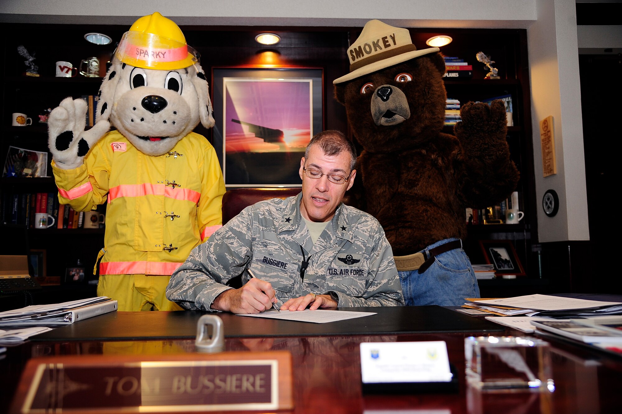 Brig. Gen. Thomas Bussiere, 509th Bomb Wing commander, signs the 2012 Fire Prevention proclamation with Smokey the Bear and Sparky the Fire Dog at Whiteman Air Force Base, Mo., Sept. 18. (U.S. Air Force photo/Senior Airman Cody H. Ramirez)