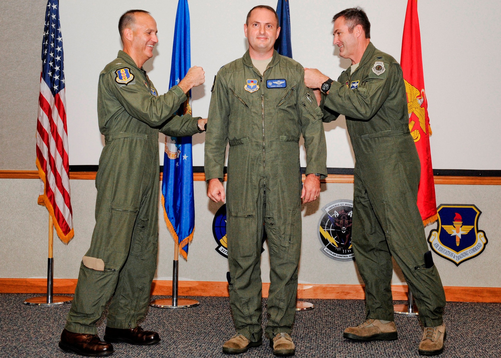U.S. Navy Capt. Michael R. Saunders, 33rd Operations Group commander, and Col. Andrew J. Toth, 33rd Fighter Wing commander, both from Eglin Air Force Base, Fla., tack on Lt. Col. Gary Smith, 337th Air Control Squadron commander, new patches in conjunction with the squadron’s move from the 325th Fighter Wing to the 33rd FW. (U.S. Air Force photo by Chris Cokeing)