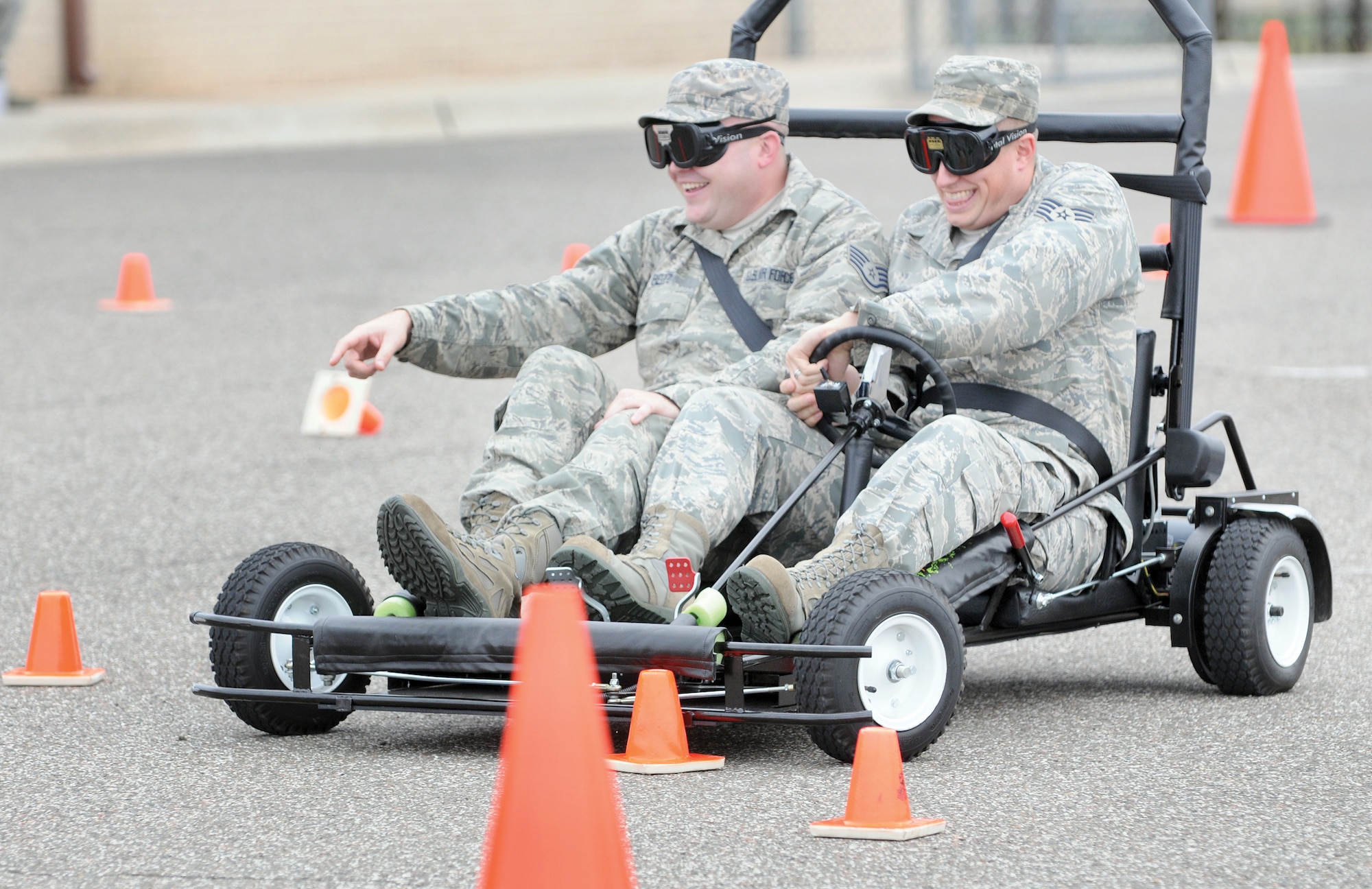 Wearing goggles that simulate driving at night with a high .25 blood alcohol content, Staff Sgt. Jason Baer, right, and Staff Sgt. Joshua Reitz, try unsuccessfully to navigate a course without taking out safety cones or weaving off course during Sept. 28 DUI prevention training. The specially equipped go-cart was controlled by Sgt. Jason Yingling of the Oklahoma Highway Safety Office who taught the class at the 
34th Combat Communications Squadron compound at Tinker. Sergeant Yingling could set the vehicle for impaired mode that gave the driver slower response time and simulated overreacting on the road as an impaired driver would when drunk or even while phone texting.