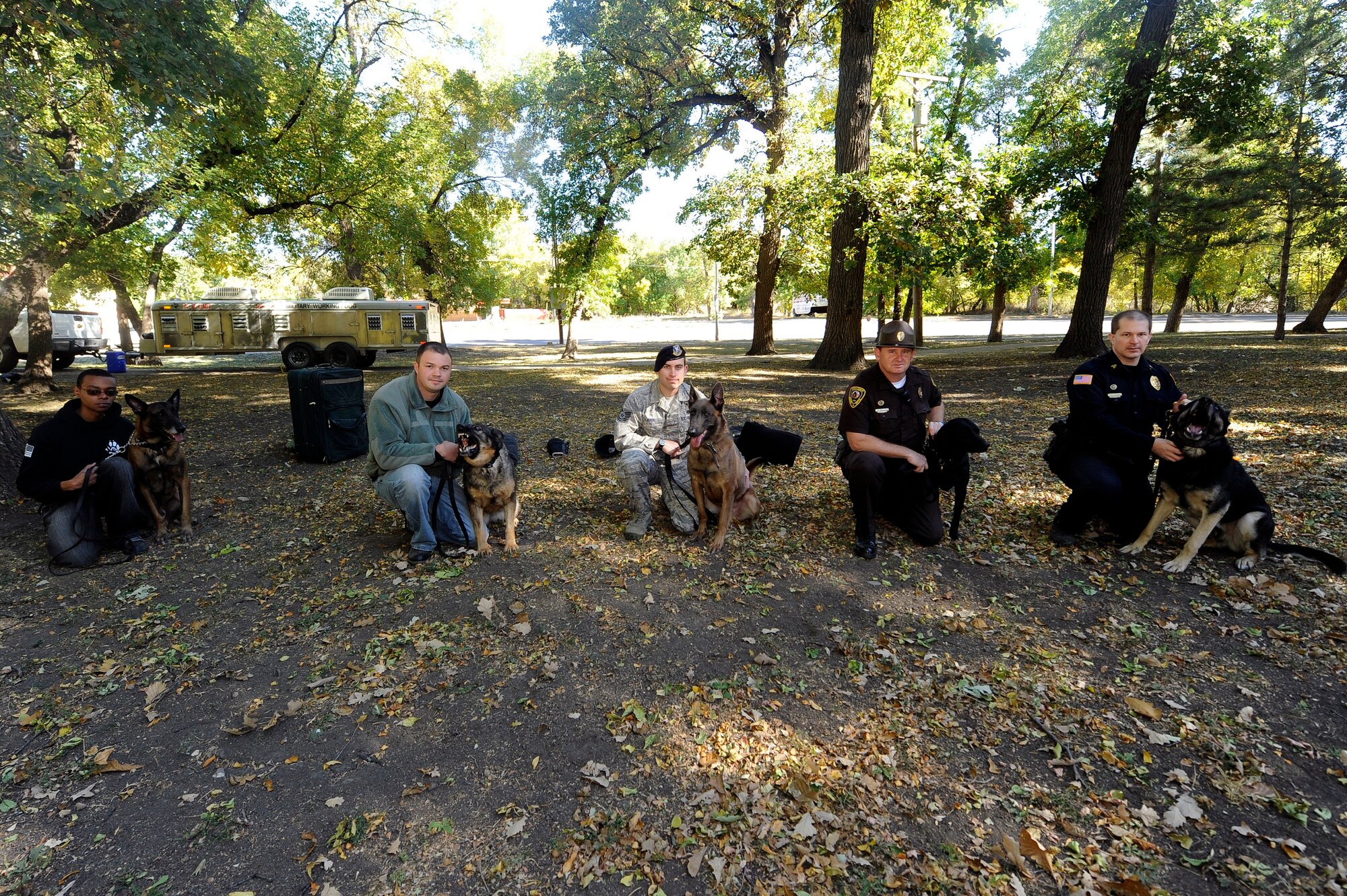 MINOT, N.D -- Military Working Dog Handler Staff Sgt. Christopher Bennett, Military Working Dog Arno, MWD Handler Staff Sgt. David Wyrick, MWD Kitty, MWD Handler Tech Sgt. Steven Kaun, MWD Legend, and Local Police Officer David Chapman, K-9: Saiber, and Local State Trooper Mike Schott, K-9: Jett, all pose during a training event held at Oak Park, Sept. 22. (U.S. Air Force photo/Senior Airman Jesse Lopez)
