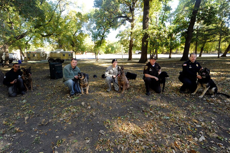 MINOT, N.D -- Military Working Dog Handler Staff Sgt. Christopher Bennett, Military Working Dog Arno, MWD Handler Staff Sgt. David Wyrick, MWD Kitty, MWD Handler Tech Sgt. Steven Kaun, MWD Legend, and Local Police Officer David Chapman, K-9: Saiber, and Local State Trooper Mike Schott, K-9: Jett, all pose during a training event held at Oak Park, Sept. 22. (U.S. Air Force photo/Senior Airman Jesse Lopez)
