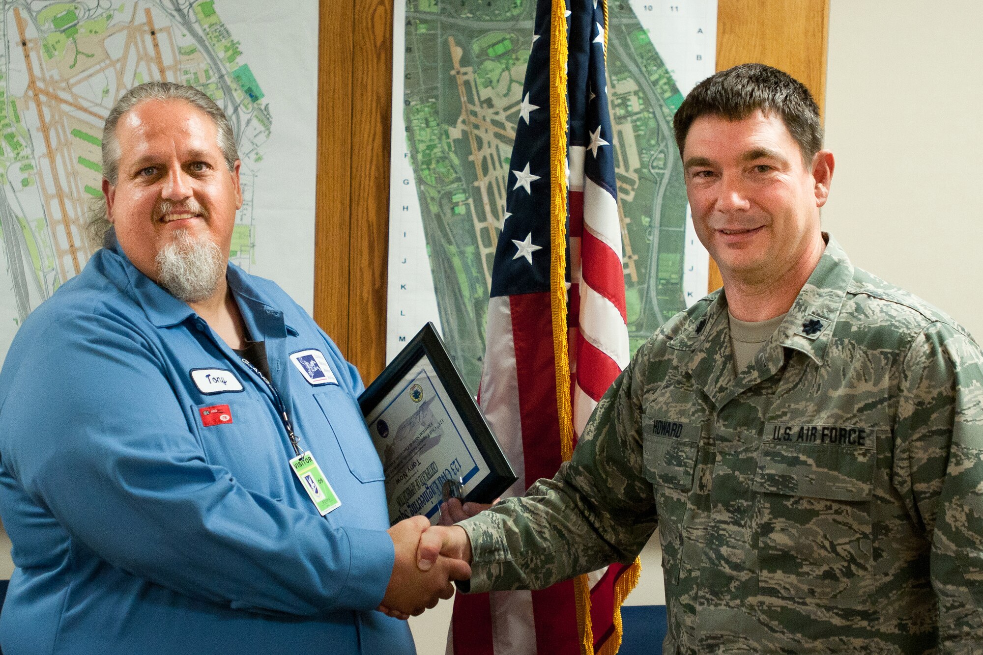 Kentucky Air National Guard Lt. Col. Phillip Howard, commander of the 123rd Civil Engineer Squadron, presents a certificate to Tony Roy, an airfield technician with the Louisville Regional Airport Authority in Louisville, Ky., on Sept. 21, 2012. Roy helped train Kentucky Air Guard civil engineers on the maintenance of commercial airfield lighting equipment, which enhanced their mission effectiveness during a 2011 deployment to Afghanistan. (Kentucky Air National Guard photo by Master Sgt. Phil Speck)